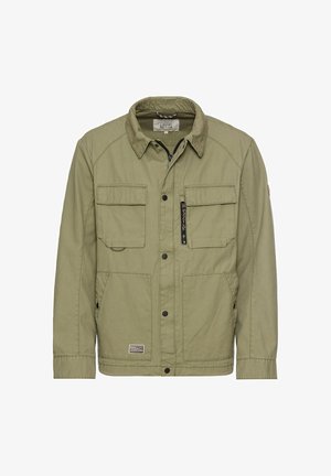 Olive green canvas jacket with a collar, four front pockets, zippered pocket, and discreet label patch. Button closure and textured fabric.