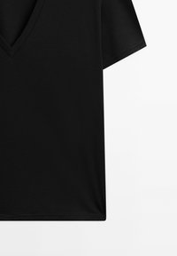 Schwarzes V-Ausschnitt-T-Shirt mit kurzen Ärmeln, aus glattem Stoff gefertigt. Es hat eine lockere Passform und einen geraden Saum, ideal für lässige Outfits.