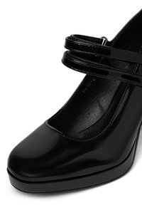 Melna lakota ādas platforma kurpe ar noapaļu purngalu un dubultu potītes siksniņu dizainu. Gluda tekstūra un augsta papēža forma papildu pacelšanai.