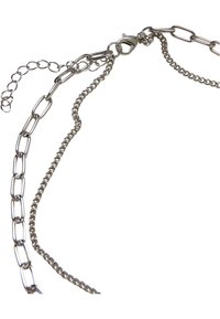 Collier en chaîne métallique avec un mélange de grands anneaux et de petits anneaux ronds en finition argentée. Comprend un fermoir à ressort pour la fermeture.