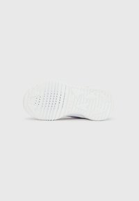 White sneaker sole with textured grip and small perforations, displayed horizontally on a plain white background.