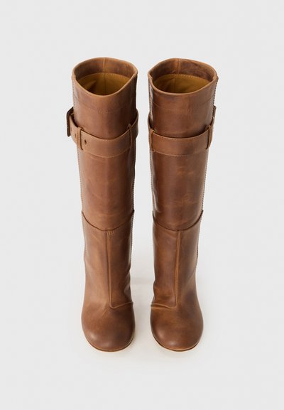 Brown leather knee-high boots with a smooth texture, rounded toe, and fabric lining. Features a leather strap accent at the top.