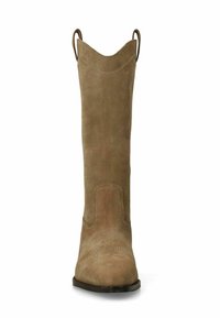 Bottine en daim beige avec un embout pointu et des languettes de tirage. Présente des détails de coutures subtils et une surface légèrement texturée.