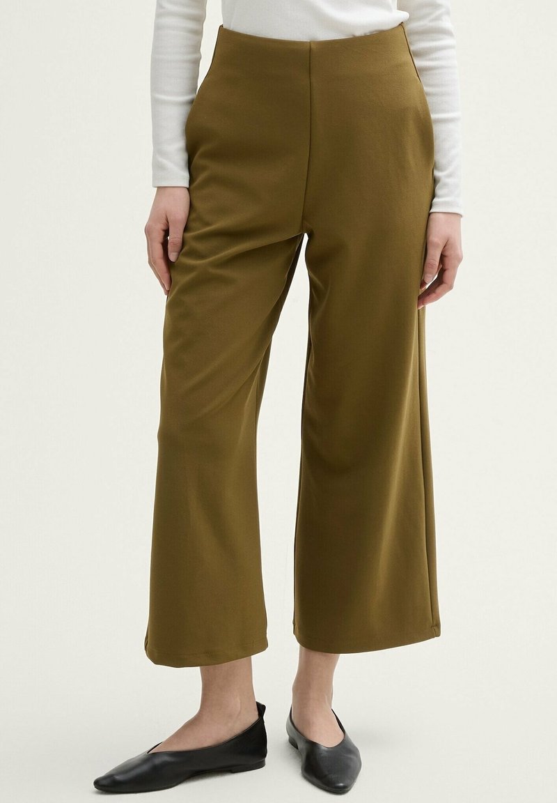 Olive green wide-leg pants made of smooth fabric, featuring a high waistband and clean seams, paired with black flat shoes.