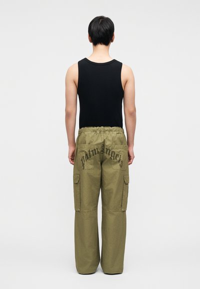 Ελιάς cargo παντελόνι με ελαστική μέση, με δύο πλαϊνές τσέπες και μεγάλο λογότυπο τυπωμένο στην πίσω τσέπη. Μαύρο αμάνικο τοπ.