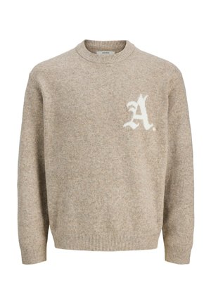 Pull en laine beige avec col, poignets et bas côtelés, arborant une lettre "A" blanche stylisée sur la poitrine gauche.