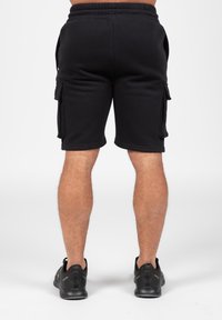 Black cargo shorts with an elastic waistband, knee-length, featuring side pockets, made from a soft, breathable fabric.