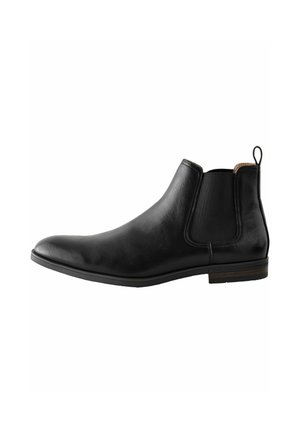 Bota Chelsea de cuero negro con paneles laterales elásticos, textura suave, punta redondeada y un acento marrón en el talón.
