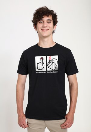 Czarny bawełniany t-shirt z humorystyczną grafiką składającą się z dwóch paneli: jeden przedstawia palec na przycisku, a drugi pokazuje dłonie z liniami ciepła.