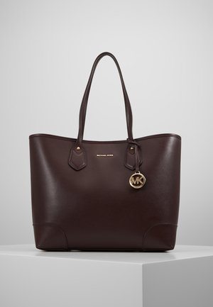 Ciemnobrązowa skórzana torba typu tote z podwójnymi uchwytami, złotym zawieszonym logo "MK" oraz małym złotym napisem "Michael Kors" z przodu.