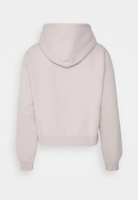 Kort hoodie i mjuk rosa tyg med huva, ribbade ärmslut och nederkant. Slät textur utan synliga logotyper eller mönster.