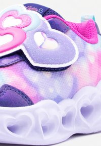 Παιδικό αθλητικό παπούτσι σε μωβ και ροζ χρώμα με λαμπερά διακοσμητικά σε σχήμα καρδιάς στο λουράκι και καρδιές κομμένες στη λευκή σόλα.