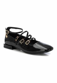 Zapato plano de charol negro con punta afilada, que presenta múltiples correas delgadas y acentos de hebilla dorada. Tacón bajo tipo bloque.