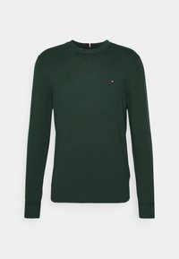 Zielony sweter z okrągłym dekoltem wykonany z miękkiego dzianinowego materiału. Posiada długie rękawy oraz niewielkie logo na piersi. Ogólnie gładka tekstura.