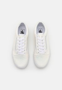 Des baskets blanches avec une finition brillante et irisée, dotées d'un design basse, de lacets blancs et d'un intérieur rembourré. Semelle en caoutchouc classique.