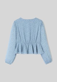 Haut peplum floral bleu à manches longues ; présente une taille froncée et un délicat motif de feuilles blanches sur un tissu léger.