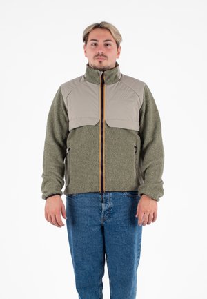 Zielona bluza polarowa z beżową, pikowaną górną częścią, pomarańczowym zamkiem błyskawicznym i bocznymi kieszeniami na zamek. Posiada wysoki kołnierz i teksturowaną tkaninę.