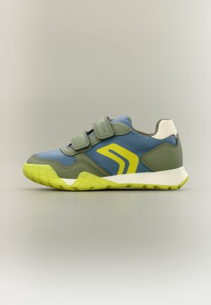 Baskets pour enfants bleu et vert avec des accents jaunes, deux bandes Velcro et un patch talon blanc sur fond neutre.