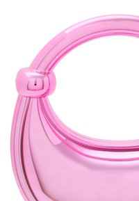 Lyserød plastik håndtaske med en glat, skinnende overflade og et buet håndtag med en rund detalje nær toppen. Slankt design med en moderne æstetik.