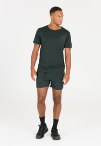 Mörkgrön idrottströja och shorts set, tillverkat av lättviktig tyg, med rund hals, korta ärmar och subtila varumärkesdetaljer.