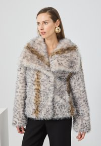 Chaqueta de piel sintética con un amplio cuello, que presenta una mezcla de colores gris y crema, acentos de estampado de leopardo y mangas largas y suaves.