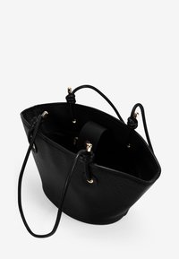 Bolso de cubo de cuero negro con detalles en hardware dorado, exterior texturizado y interior suave. Cuenta con cierre de cordón ajustable y asas dobles.
