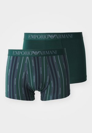 Deux paires de boxers Emporio Armani. L'une est d'un vert foncé uni ; l'autre présente des rayures verticales en vert foncé et bleu avec un logo décoratif.