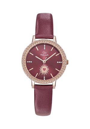 Montre ronde bordeaux avec bracelet en cuir, lunette en or rose ornée de cristaux, motif cœur rayonnant à 6 heures et index des heures en cristaux.