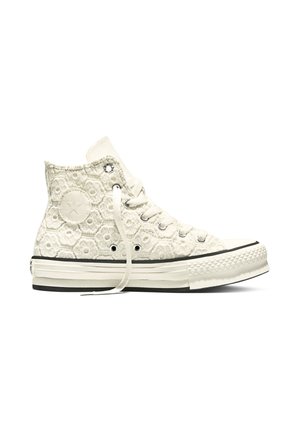 Weißer hoher Sneaker mit vorderseitiger Schnürung, floralem Häkelmuster und gummisohle mit schwarzen Streifen.
