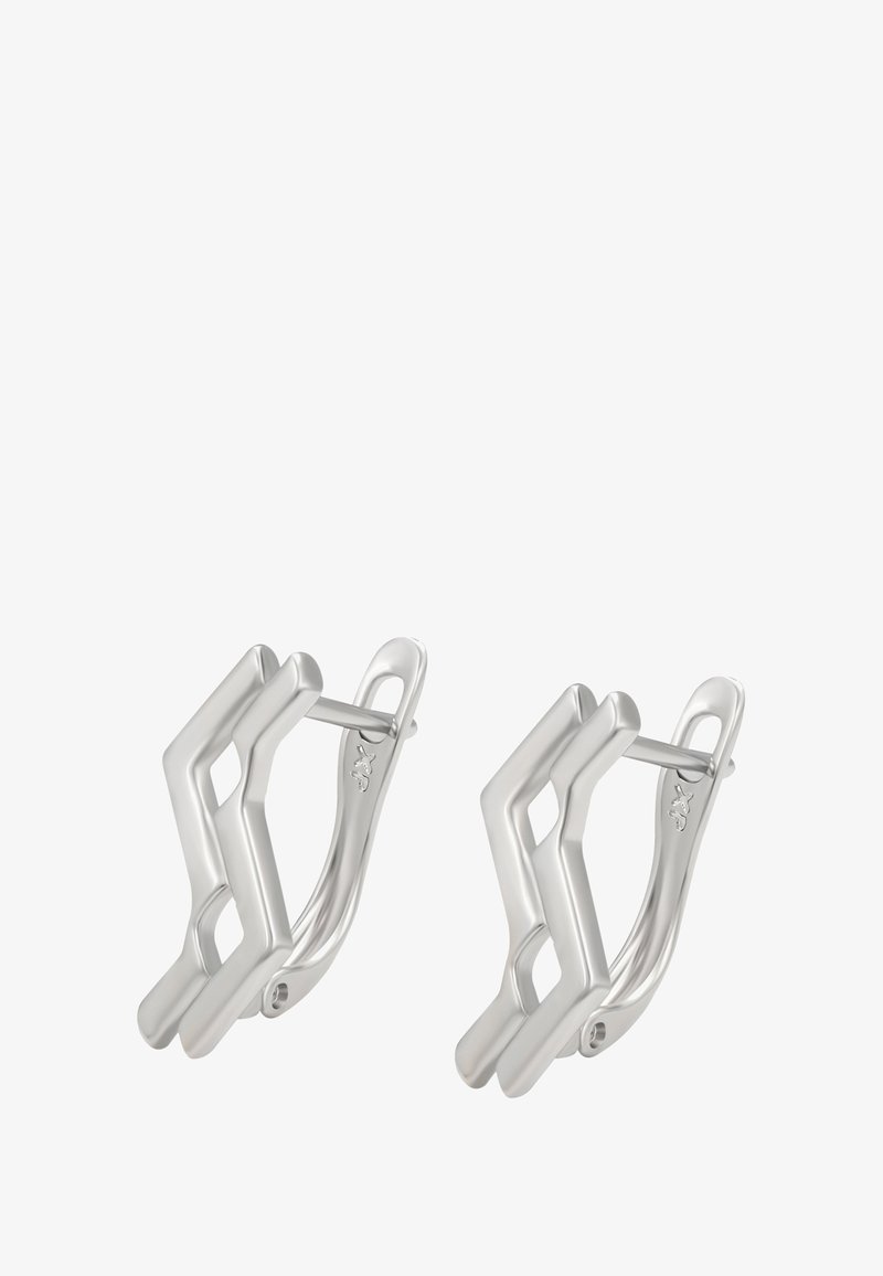 Pár strieborných geometrických kruhových náušníc s uhlovým zigzagovým dizajnom a pántovými sponami na bielom pozadí.