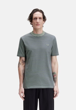 Camiseta a rayas en verde y azul marino, hecha de tejido suave. Presenta un cuello redondo acanalado y un sutil logo bordado en el pecho.