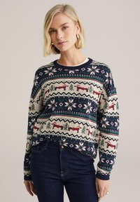 Pletený svetr v námořnické modři s multikolorovým vzorem Fair Isle, na kterém jsou zobrazeny stromy a lišky. Kulatý výstřih, žebrované manžety a spodní lem. Měkká textura.