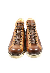 Scarpe alte in pelle marrone con design testurizzato, caratterizzate da tonalità marrone scuro e cuoio, chiusura con lacci davanti e suola spessa color crema.