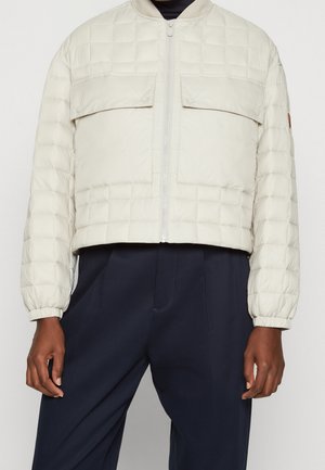 Jasno beżowa pikowana kurtka typu puffer z dwiema przednimi kieszeniami, zapięciem na zamek i ściągaczami przy mankietach; krótki fason o miękkiej, gładkiej fakturze.
