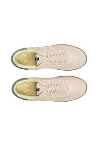 Beige ruskindsneakers med lysegule accenter, perforeret tunge og grøn hældetalje. Gummisål. Klassisk atletisk skodesign.