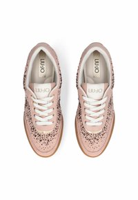 Baskets roses avec des accents scintillants, des lacets blancs et une semelle en caoutchouc beige. Logo de la marque sur la languette et matériau texturé sur toute la chaussure.