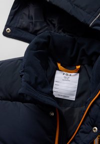 Laivastonsininen toppatakki pehmeällä fleecevuorella, oranssilla vetoketjulla ja heijastavilla raidalla. Sisältää hoito-ohjeen kauluksessa.