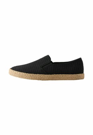Schwarzer Slip-On-Espadrille mit strukturiertem Stoffobermaterial und geflochtenem Jutesohlen auf weißem Hintergrund.