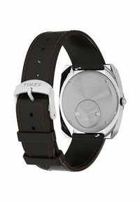 Zadní strana náramkových hodinek Timex se stříbrným pouzdrem, černým koženým páskem, hnědým prošitím a vyrytým názvem značky na sponě a na zadní straně pouzdra.