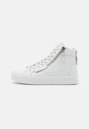 Biały sneaker za kostkę z bocznym zamkiem błyskawicznym i sznurowadłami, grubą płaską podeszwą i gładką skórzaną cholewką na jednolitym jasnym tle.