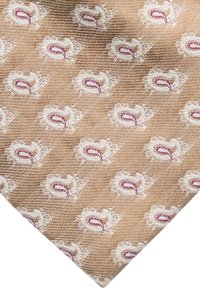 Beige stof met een gestructureerde weef, met een herhaald patroon van witte bloemmotieven met paarse accenten.