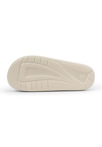 Cremefarvet sneakersål med en struktureret gummioverflade og dybe slidbanemønstre for greb, med en let hævning ved tæerne.