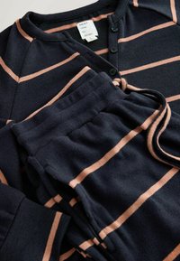 Set de loungewear cu dungi navy, format dintr-o bluză cu nasturi, guler rotund și pantaloni asortați cu talie elastică, confecționați dintr-un material moale cu dungi roz.
