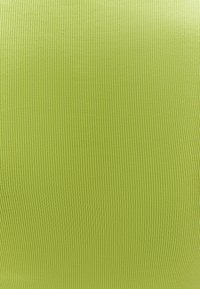 Tissu vert lime éclatant avec une texture à côtes verticales. Matériau lisse et léger avec une couleur et un motif uniformes sur toute la surface.