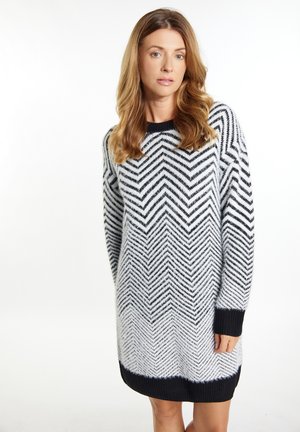 Rochie tricotată în model herringbone alb-negru, cu mâneci lungi, decolteu rotund și tivuri și manșete cu nervuri.