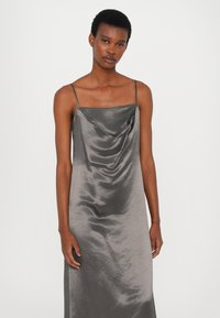 Satin dress with cowl neck in muted grey, featuring thin shoulder straps and a fluid drape that accentuates the silhouette.