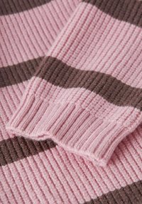 Rippstrickstoff mit abwechselnden rosa und braunen Streifen. Die Textur wirkt weich mit einem subtilen Glanz. Die Kanten sind ordentlich verarbeitet.