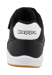 Baskets noir et blanc en matériaux mesh et cuir, semelle blanche avec un motif de traction marron clair, et le nom de la marque "Kappa" sur l'étiquette du talon.
