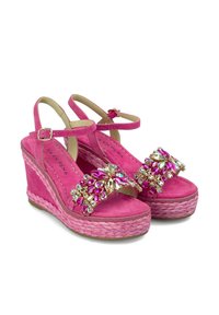 Sandales compensées en suède rose avec un accent floral en bijoux, des brides à la cheville et une semelle en jute. Semelle intérieure texturée pour le confort.