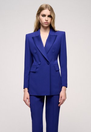 Double-breasted blazer and matching trousers in vibrant blue. Tailored fit, sharp lapels, and minimalistic button details. Smooth fabric texture.